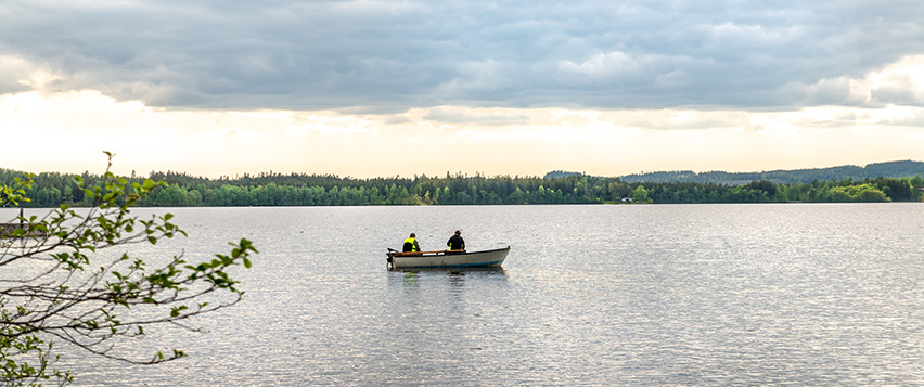 Två personer i en båt på en sjö.